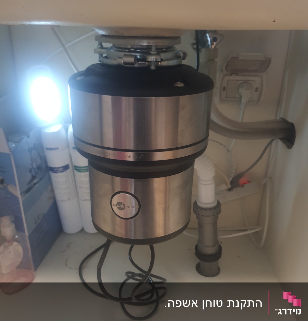 מתקן טוחן אשפה מתחת לכיור עם צינורות חיבור